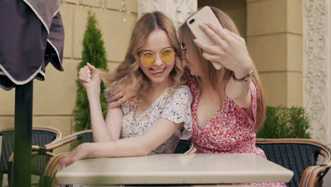 two friends taking a selfie in a cafe