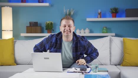 home office worker man makes heart symbol looking at camera.