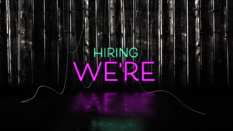 animation of we're hiring text in pink and blue neon letters on black background