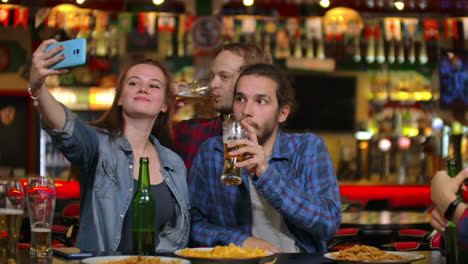 En-El-Bar-O-Restaurante,-Un-Hombre-Hispano-Se-Toma-Un-Selfie-De-Ella-Y-De-Sus-Mejores-Amigos.-Grupo-De-Jóvenes-Hermosos-En-Un-Establecimiento-Elegante.