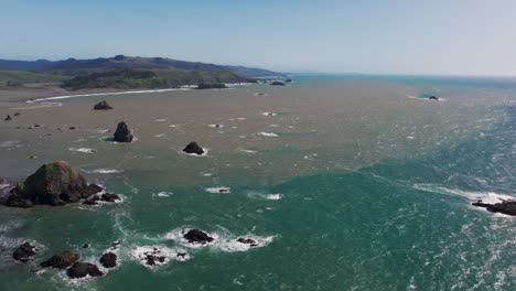 Vista-Aérea-De-Drones-Del-Agua-De-Los-Ríos-Interiores-Interactuando-Con-El-Océano-Pacífico.