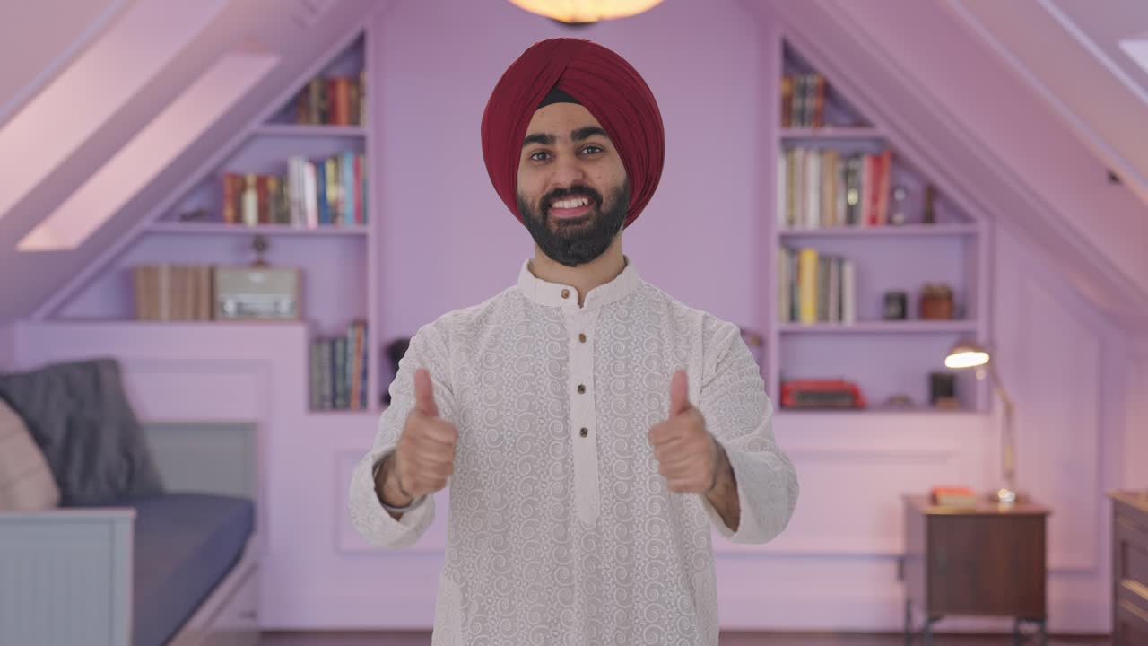 Uomo indiano Sikh felice che mostra il pollice in su