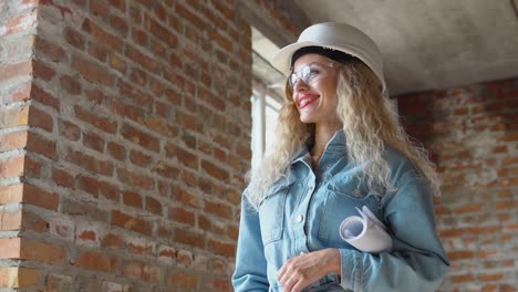 arquitecta femenina sosteniendo un plan de construcción arquitectónica mientras está en el sitio de construcción.
