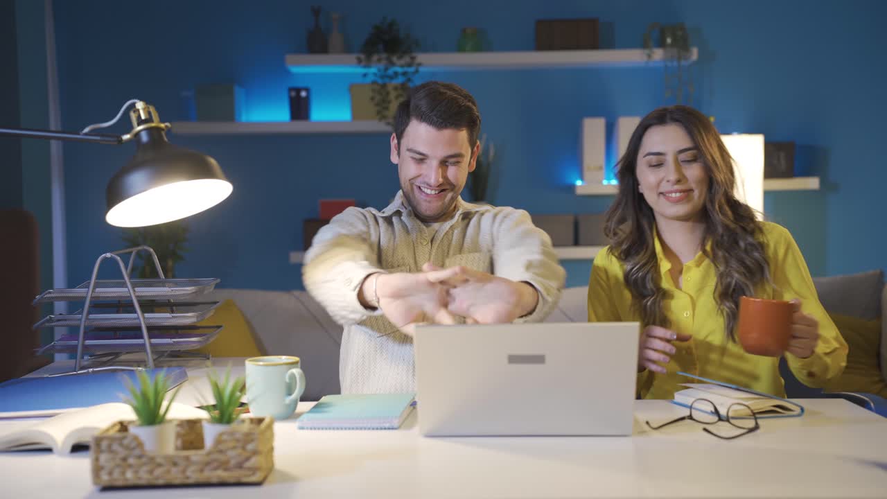 una pareja feliz trabajando juntos en una oficina en casa.