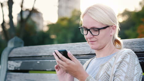 woman uses smartphone on a bench