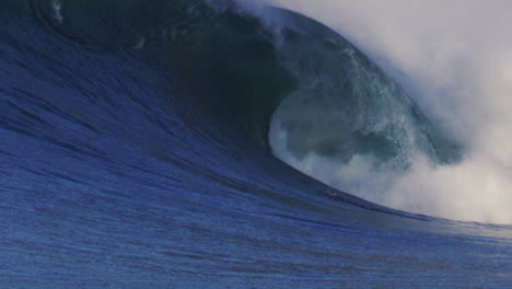 slow-motion shot of a massive ocean wave breaking in golden light, capturing the power and motion of the water