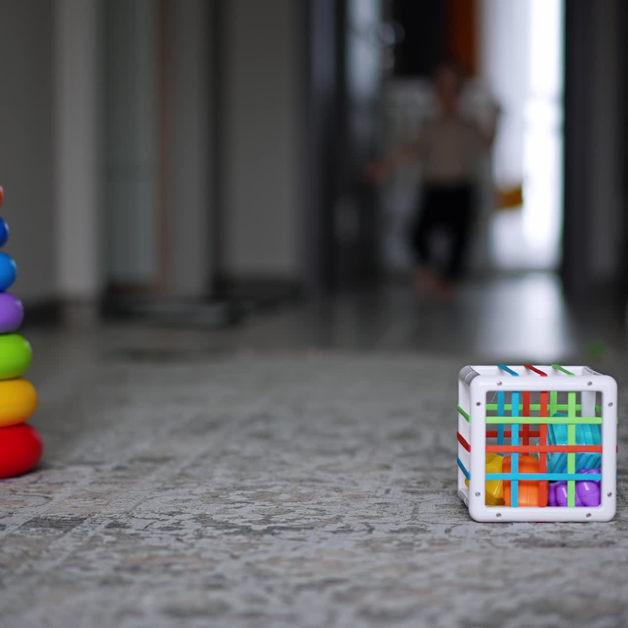 Little boy runs along the room approaching camera. Child goes past toys lying on the floor