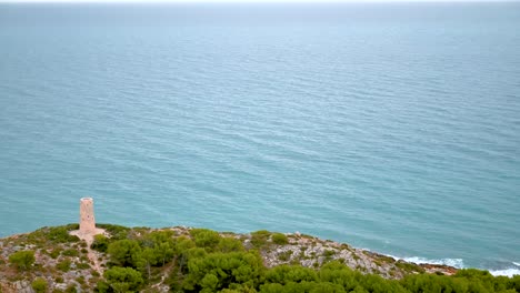 Time-lapse-Horizontal-De-4k-De-Las-Olas-Del-Mar-Mediterráneo-Llegando-Tranquilamente-A-La-Costa-Por-Una-Torre-Defensiva-Medieval-De-Piedra-En-Oropesa-Del-Mar,-España