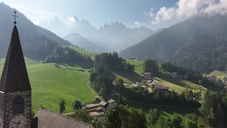 a stunning aerial view of a charming residential area set against the striking mountain backdrop of chiesa di santa maddalena and drei zinnen in the dolomites, south tyrol, funes, italy