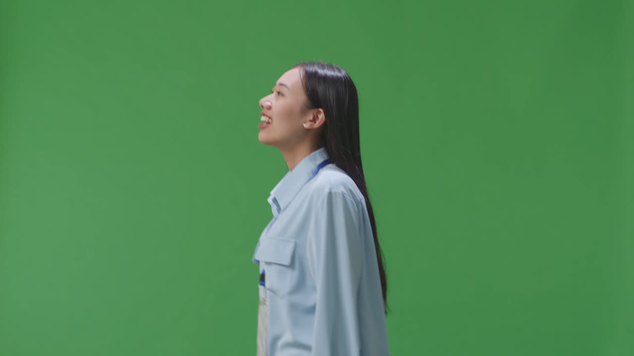 Side View Of Asian Business Woman Walking On Green Screen Background In The Studio