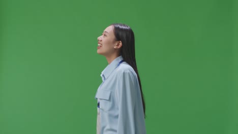 side view of asian business woman walking on green screen background in the studio