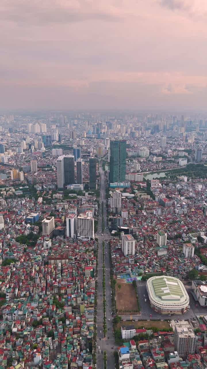 Expansive vertical drone shot of the Hanoi cityscape during the day. The dense urban sprawl, showing a mix of traditional, low-rise buildings and modern skyscrapers. Vietnam UHD