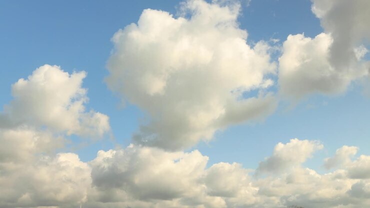 Time lapse of thick and fluffy clouds quickly passing by against a blue sky