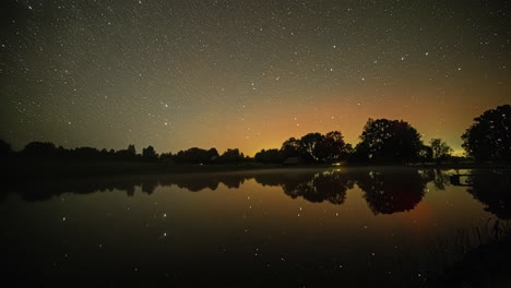 time lapse shot of flying stars at night sky with reflection on lake