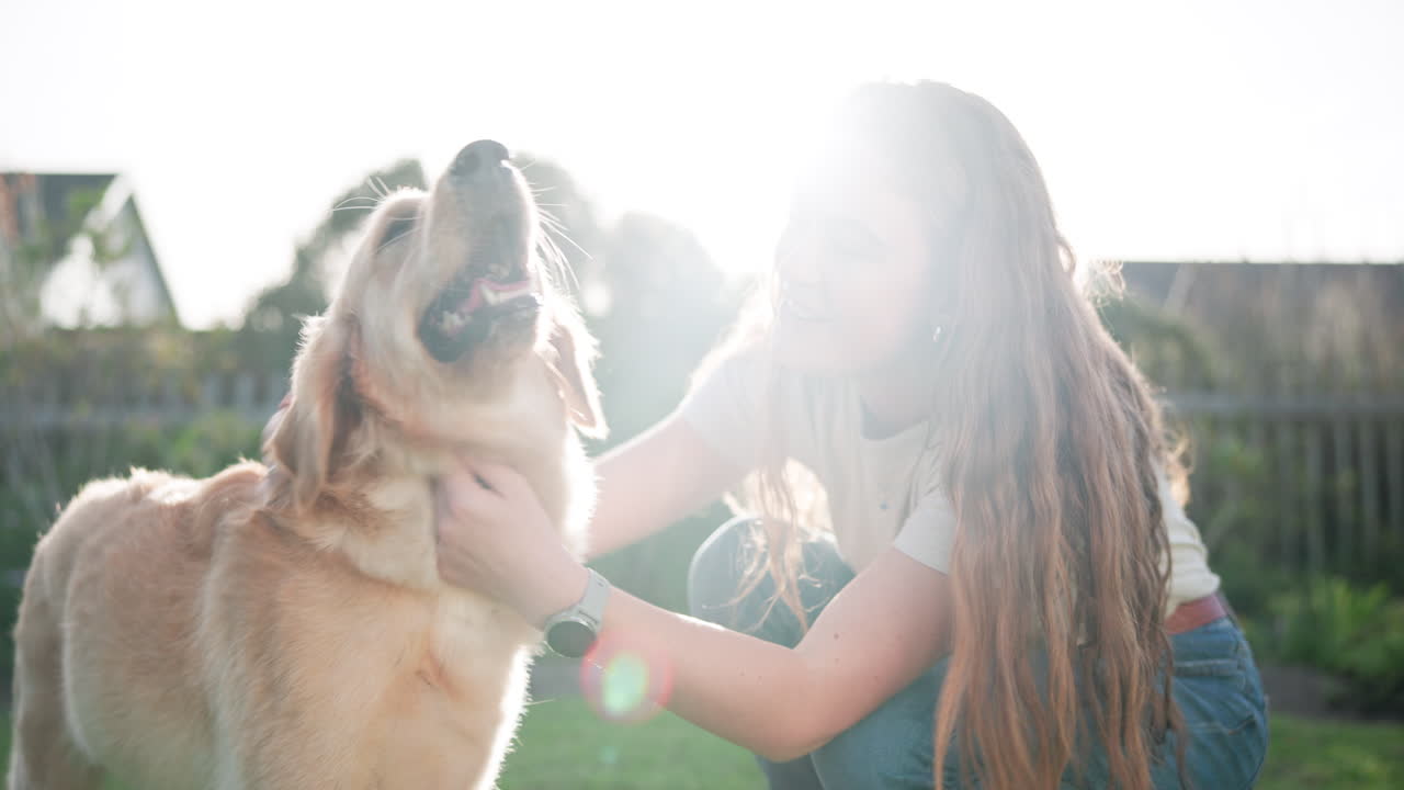 Woman petting her golden retriever in the yard