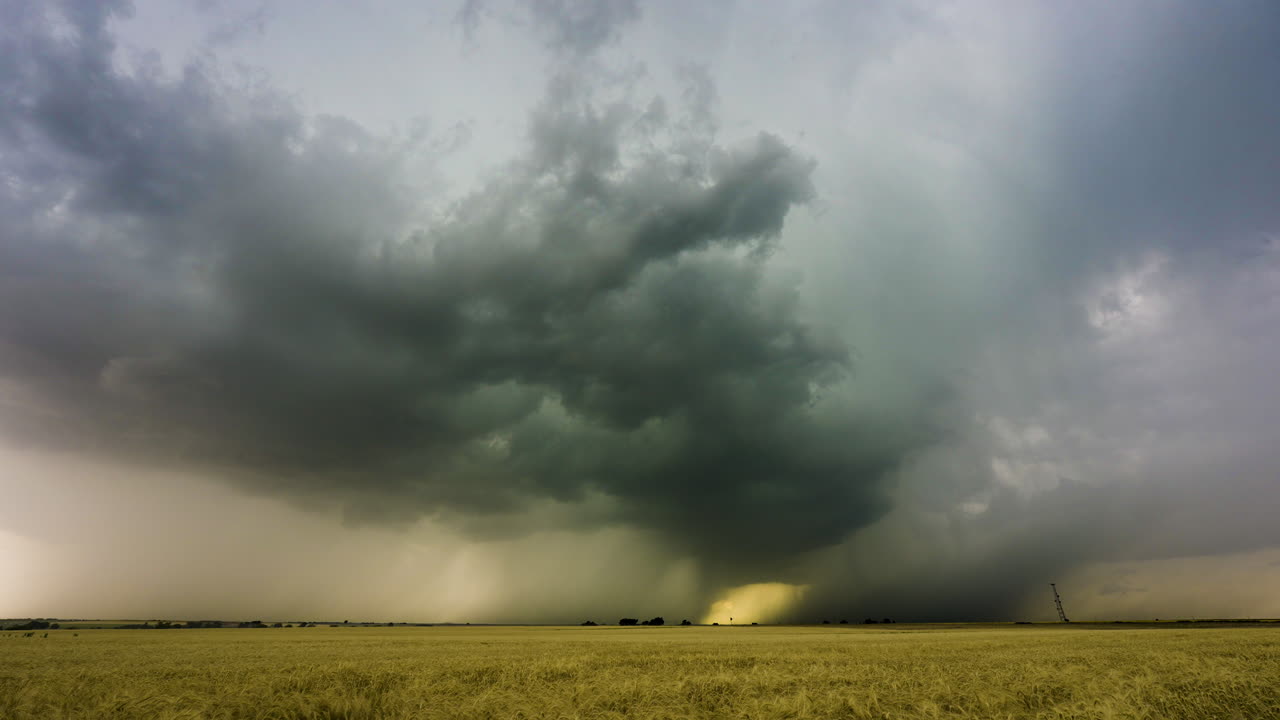 Heavy colorful rainstorm drifts by with lightning hitting the ground