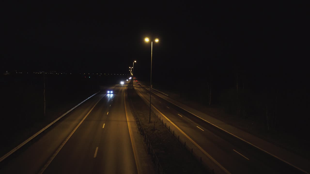 Vehicles at highway filmed from a bridge by night