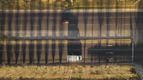 aerial top down view of vehicles running on highway surrounded by beautiful greenery and river