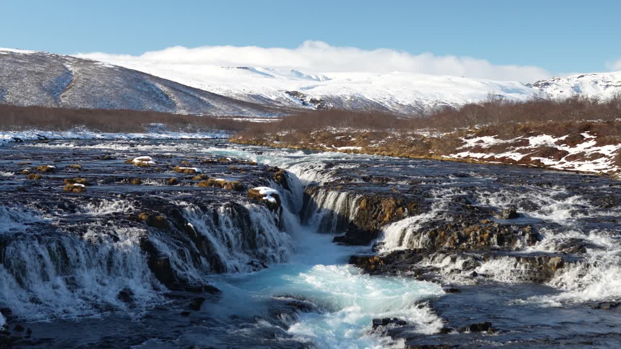 Brúarfoss waterfall in Iceland cascading through icy terrain with snow-covered hills. Laugarvatn, Haukadalur, Ísland Iceland