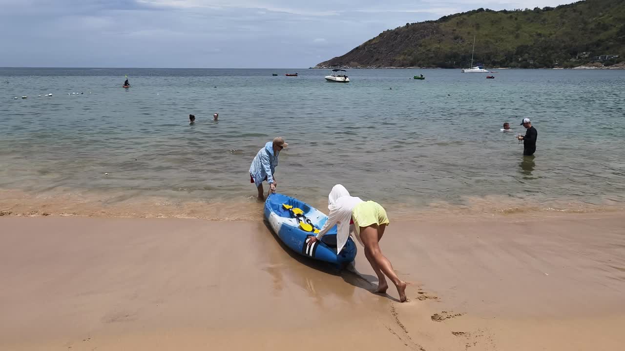 People kayaking on a tropical beach