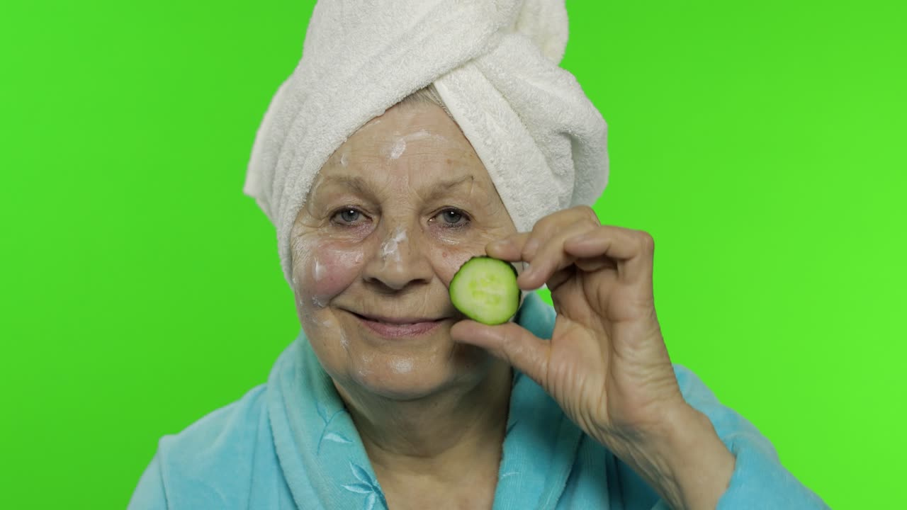 abuela anciana en bata de baño. anciana con una rebanada de pepino