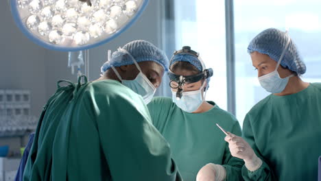 portrait of african american male surgeon during operation with diverse colleagues, slow motion