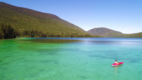vista aérea de una mujer en kayak en un lago 4k