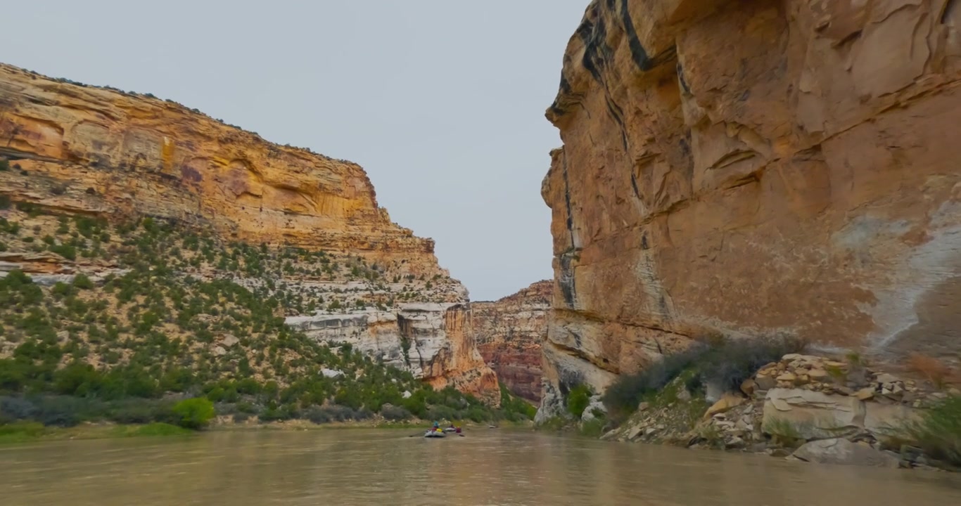 Viaggio a livello della barca attraverso imponenti pareti di canyon in arenaria lungo il fiume Yampa, esperienza di pack rafting nell'entroterra.
