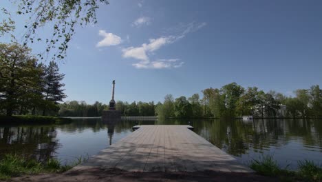 lago real en pushkin con un obelisco en agua y perforación, árboles en una isla y bengalas solares