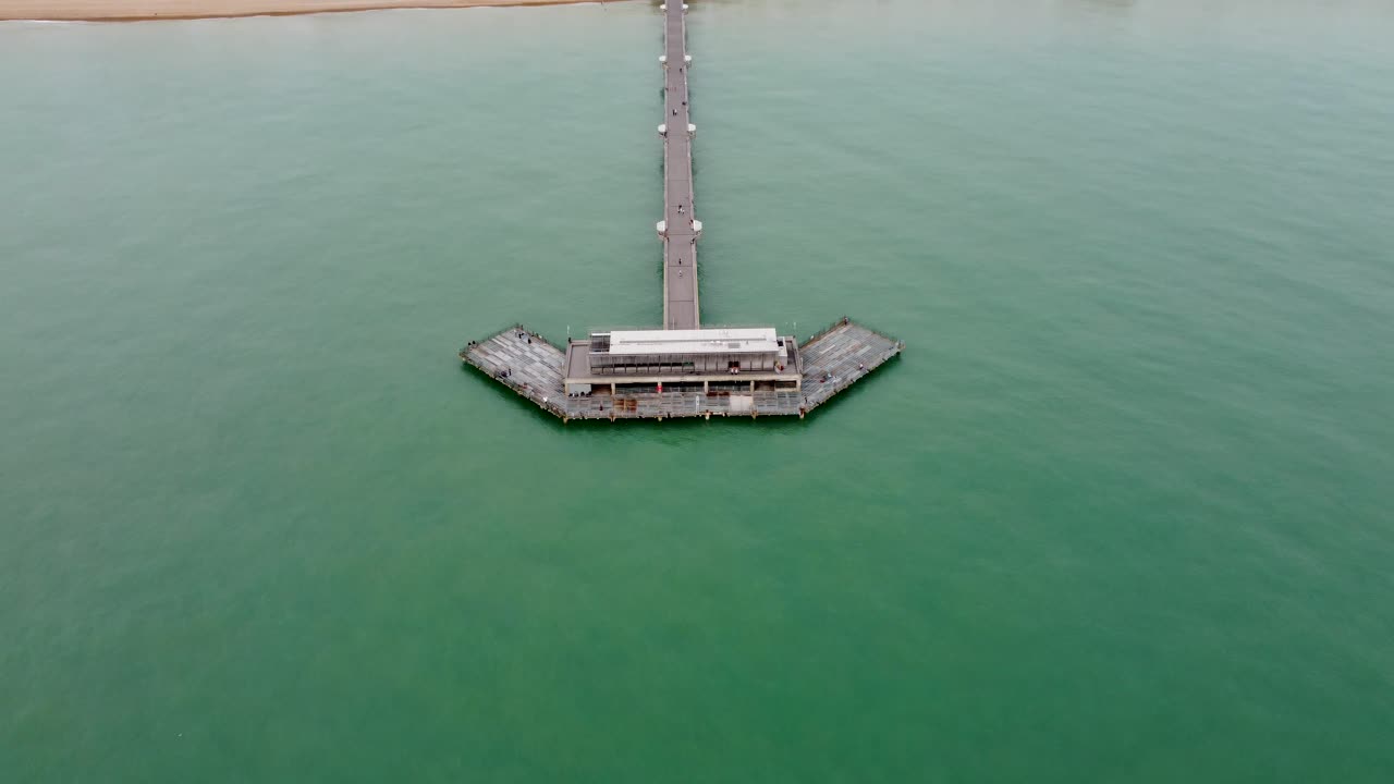 해변과 마을을 드러내는 거래 부두의 4k 고고도 드론 영상