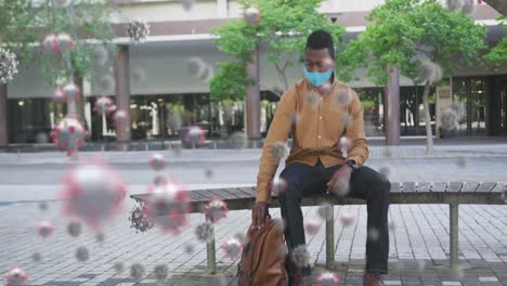 multiple covid-19 cells floating against man wearing face mask checking time while sitting on bench