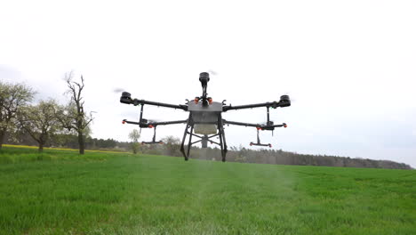Drone-Agrícola-Con-Boquillas-Rociando-Fertilizante-En-Tierras-De-Cultivo-Verdes,-Concepto-Agrícola-Moderno