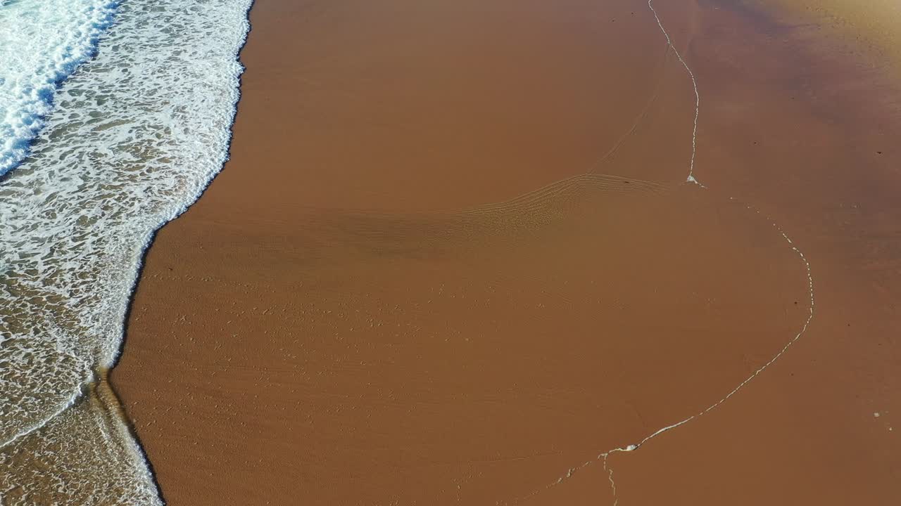 열대 해변의 공중 풍경, 열대 노란 모래 해변에서 파도가 깨지는 면 풍경, 아름다운 모래해변에서 바다 파도가 끊임없이 회전하는 풍경, 바다 파도의 새의 눈 풍경.