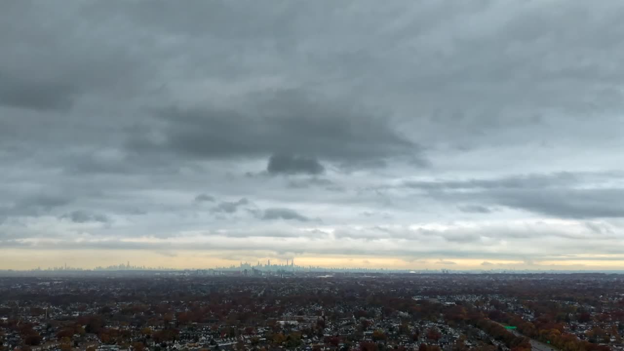 An aerial time lapse by the Southern State Parkway in the Valley Stream neighborhood on Long Island, NY on a cloudy day. It is autumn and the trees and landscape are colorful