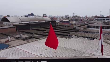 Drohnen-4K-Aufnahmen-Einer-Chinesischen-Flagge-Neben-Einer-Peruanischen-Flagge,-Die-Im-Wind-Weht