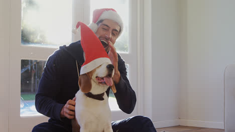 smiling young man putting santa cap on his pet dog 4k 4k