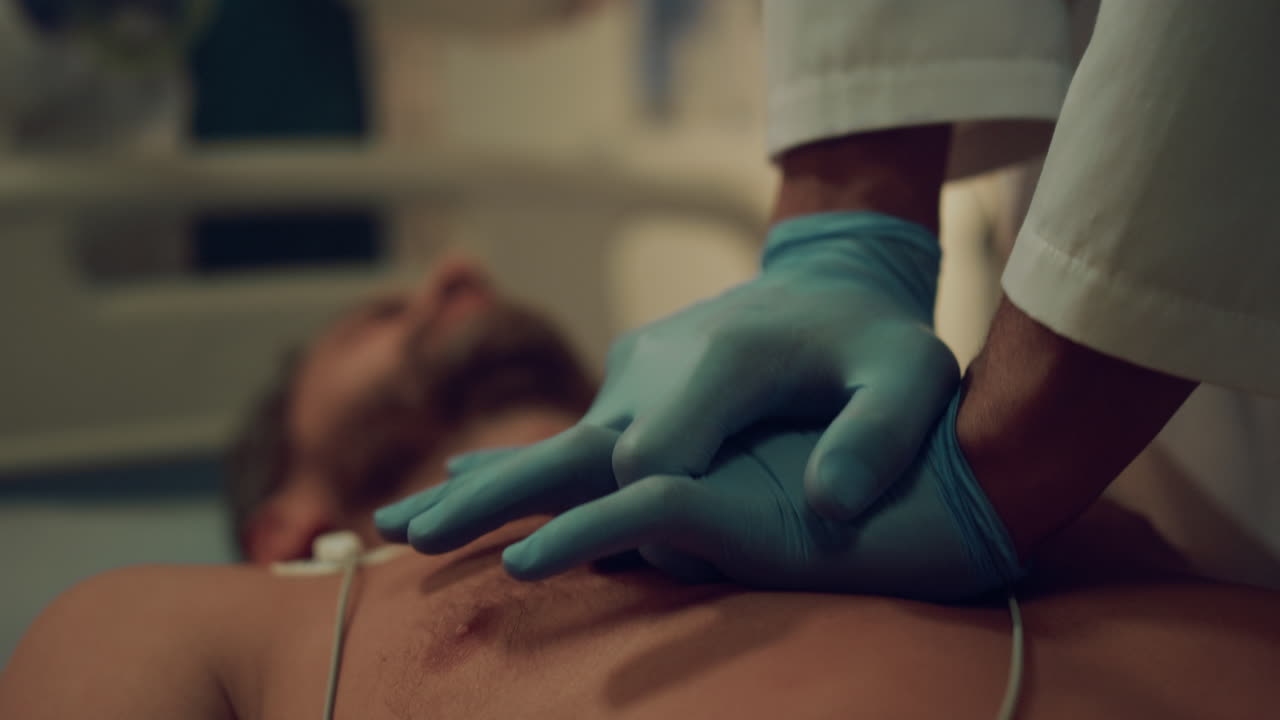 Closeup doctor doing heart massage to unconscious patient in hospital ward.