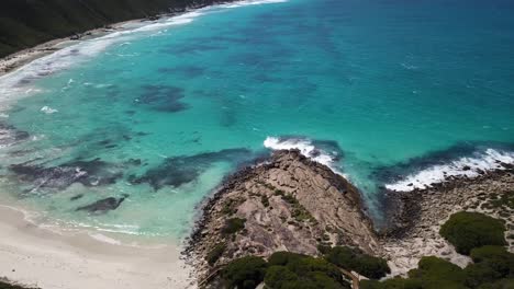 mar azul poco profundo y olas que se encuentran con una playa tranquila