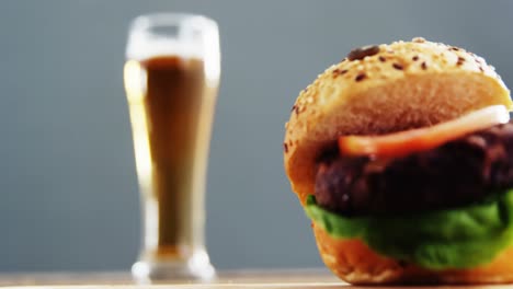 beer and hamburger against grey background