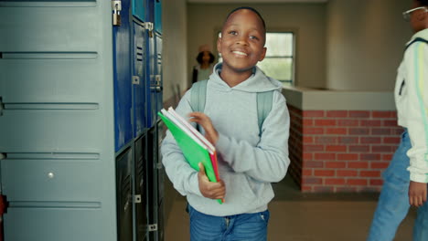 schoolboy with books in hallway