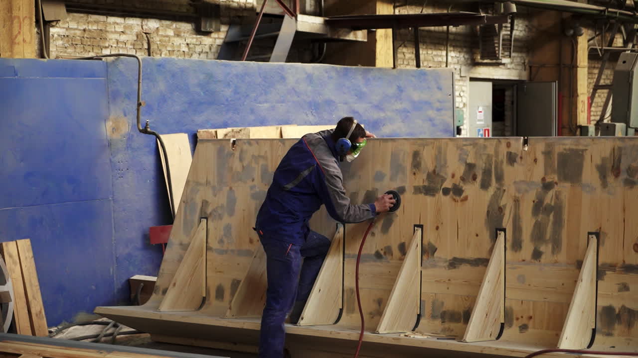 공장 에서 목재 패널 을 는 노동자