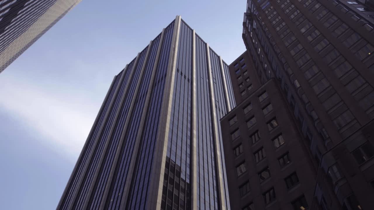 Upward rotating view modern buildings in NY. Modern glass building in the city. Corporate glass building facade on the streets of New York city