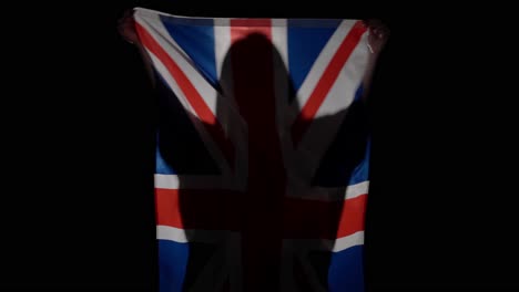 silhouette of person holding the uk flag
