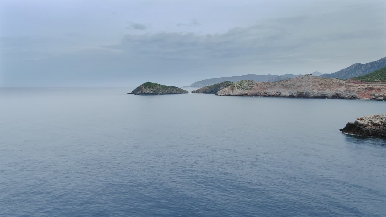 Aerial shot flying over sea on the coast of Crete Island. Dolly in