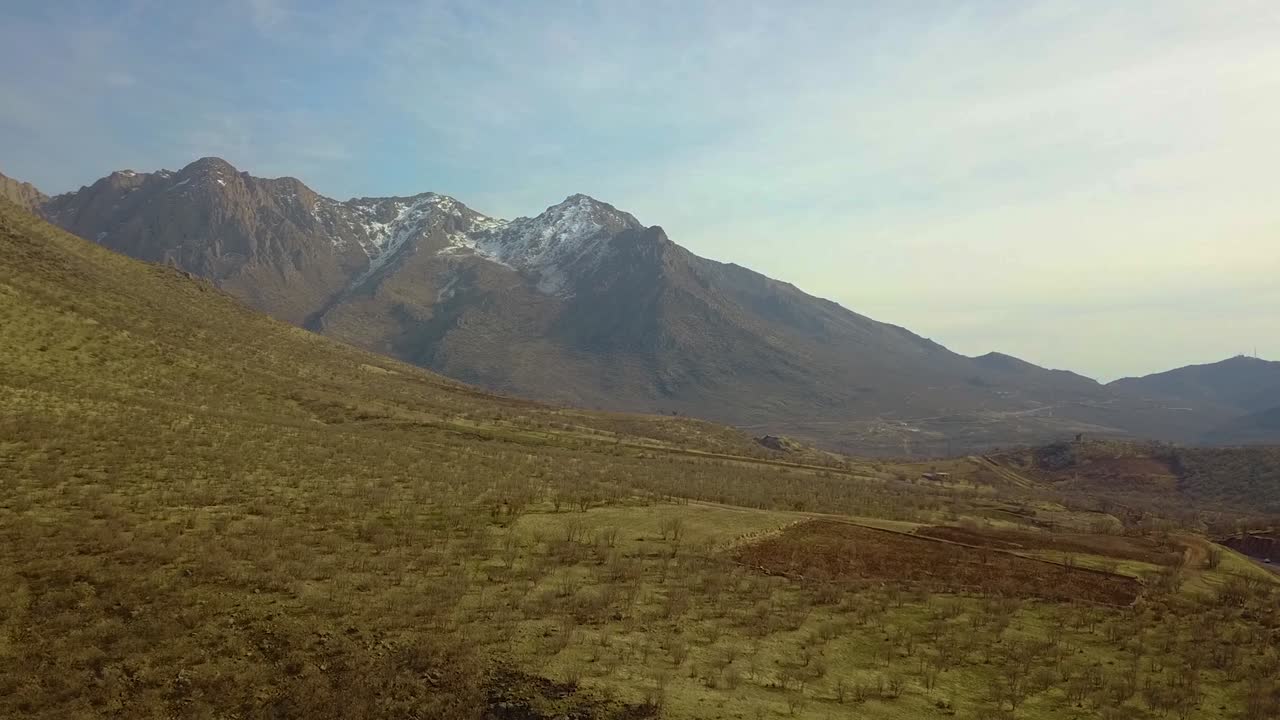 amplia vista de la naturaleza salvaje, colinas secas y paisajes montañosos cubiertos de nieve en el noroeste de irán, hora de la puesta de sol en verano, otoño, invierno, viento pequeño, cielo nublado, planta cultivada en campos agrícolas terrestres