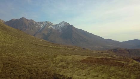 Amplia-Vista-De-La-Naturaleza-Salvaje,-Colinas-Secas-Y-Paisajes-Montañosos-Cubiertos-De-Nieve-En-El-Noroeste-De-Irán,-Hora-De-La-Puesta-De-Sol-En-Verano,-Otoño,-Invierno,-Viento-Pequeño,-Cielo-Nublado,-Planta-Cultivada-En-Campos-Agrícolas-Terrestres