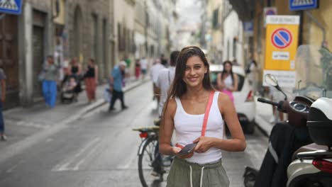 young woman walking through a city street in florence, italy