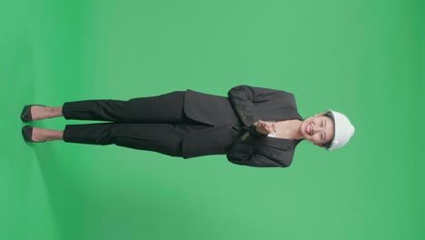 full body of smiling asian female engineer with safety helmet clapping her hands in the green screen studio