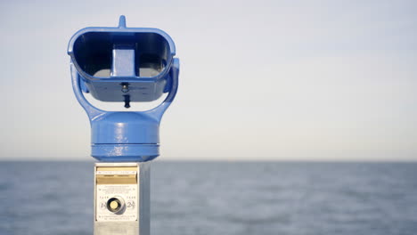 blue binoculars with water in the background at north sea, lower-saxony, germany 4k