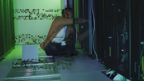 Animation of data processing over african american male it engineer and computer servers